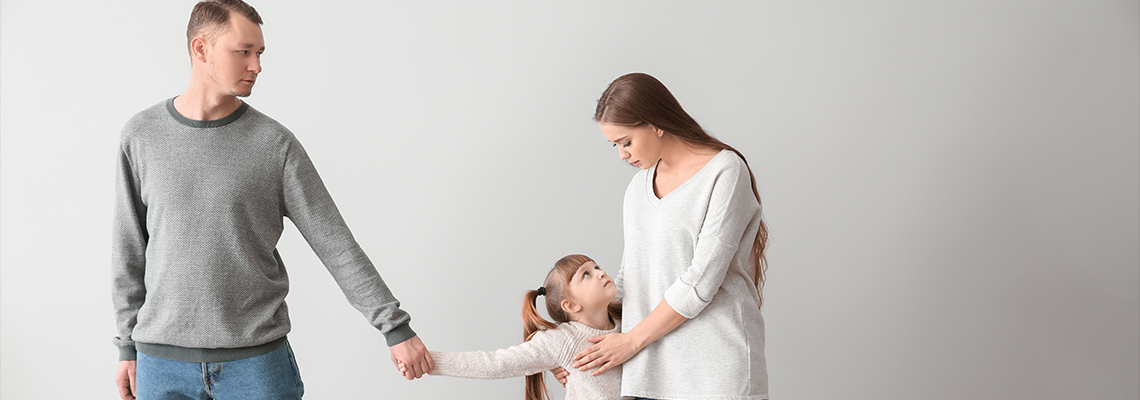 Unhappy family after divorce against light wall