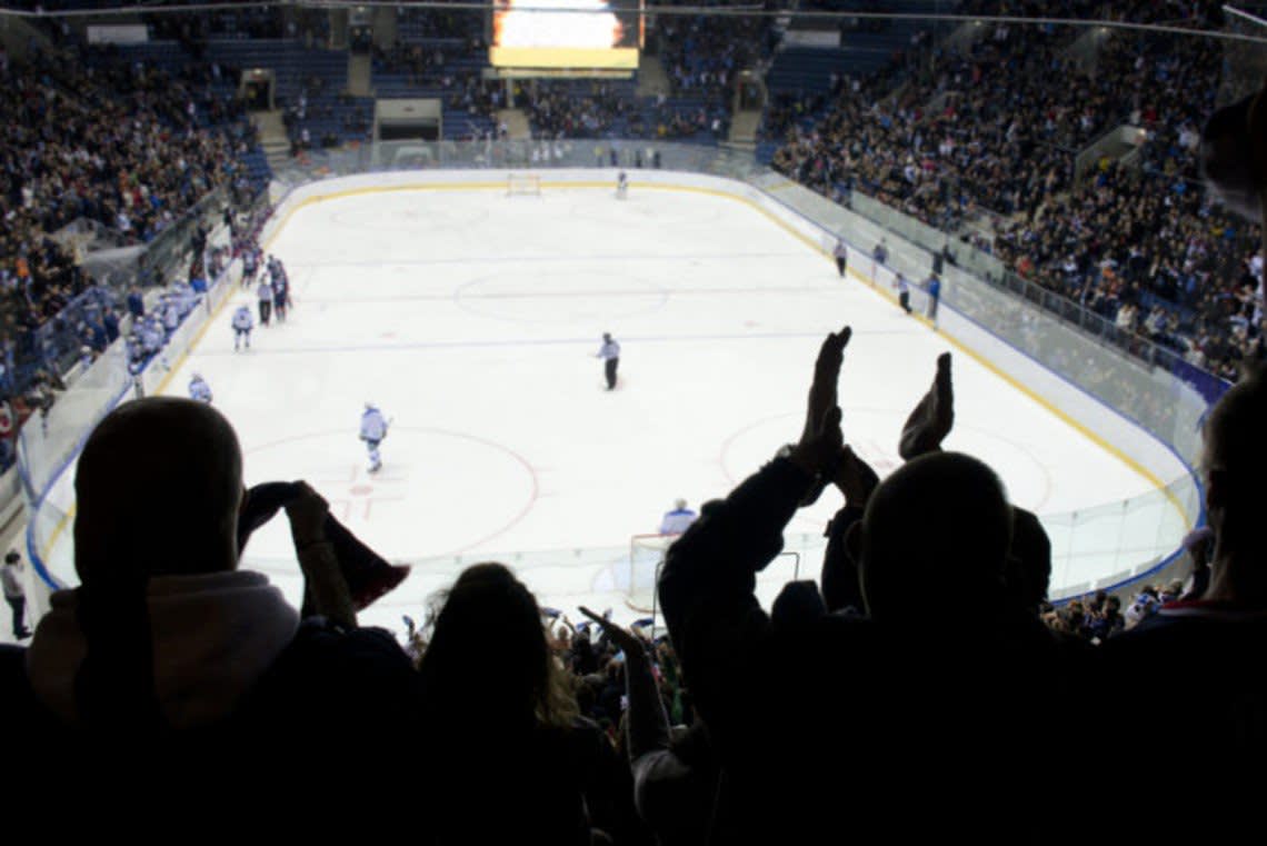 Hockey fans clapping in a full arena