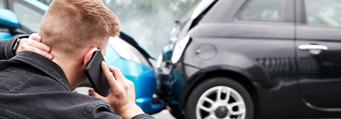 Man with whiplash injury calling for help after car accident