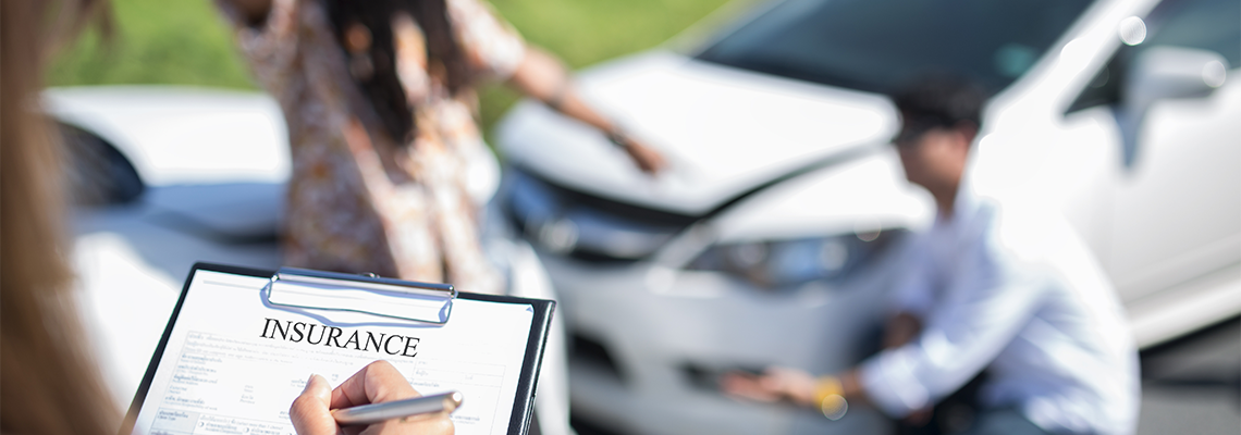 Insurance Agent Examining Car After Accident