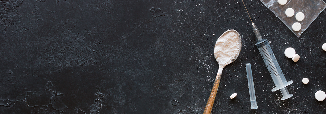 Drugs in the form of powder and tablets, a spoon and a syringe on a black background mockupDrugs in the form of powder and tablets, a spoon and a syringe on a black background