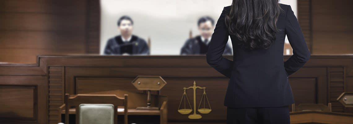 An attorney stands in front of two judges
