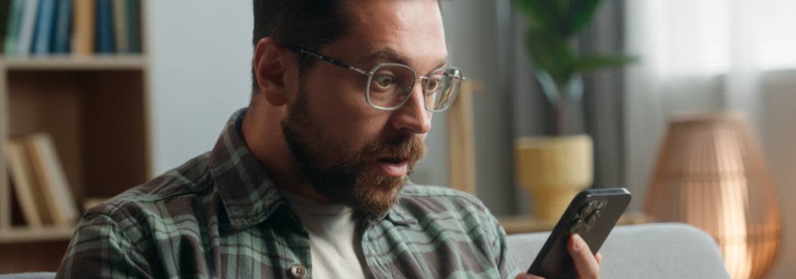 Panicked man looking at phone