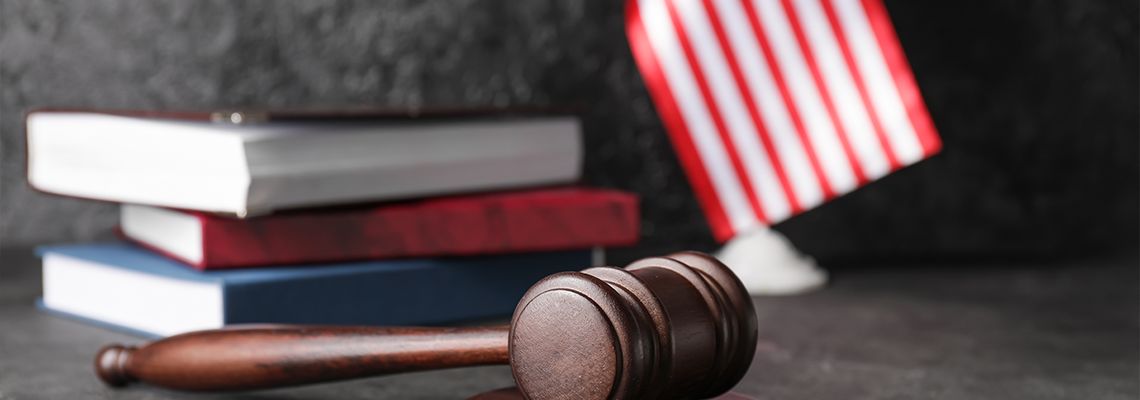 Judge's gavel with books and USA flag on dark background