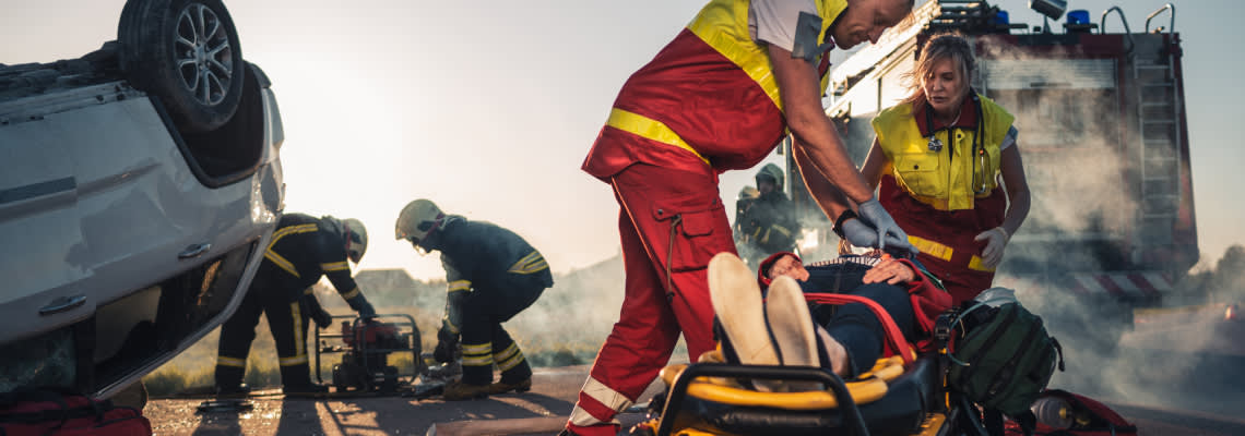 Paramedics helping a critically injured person in accident