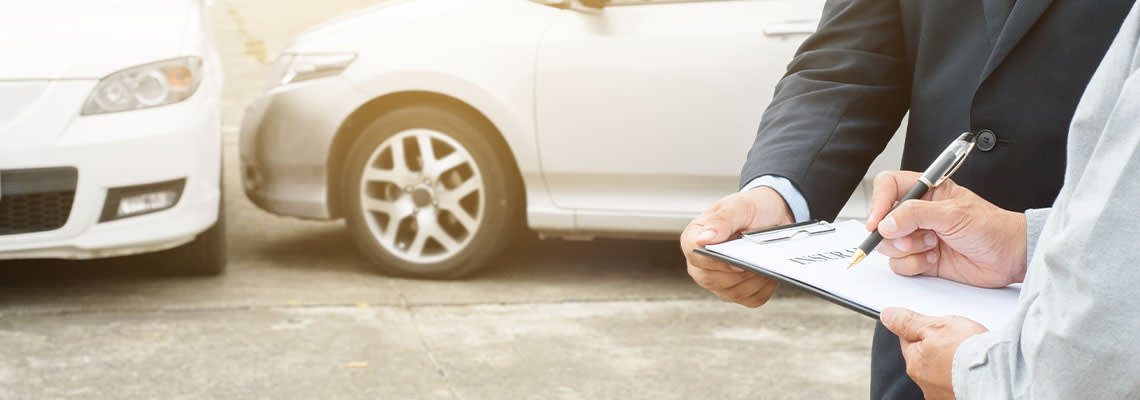 Man with insurance agent for claim process after accident