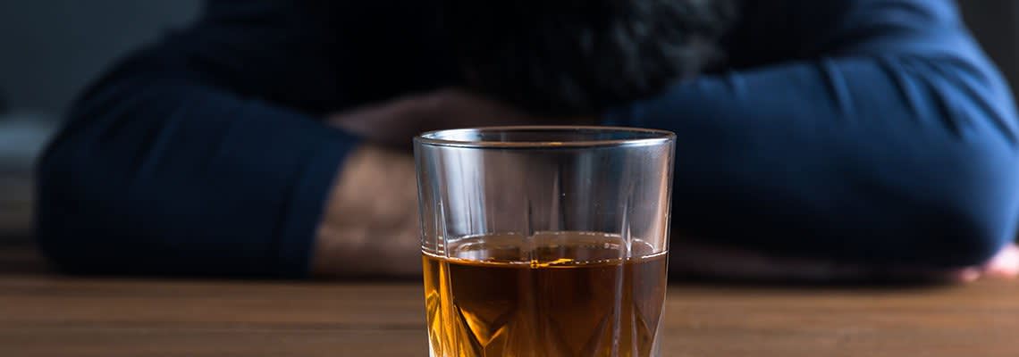 Drink in Front of Person with Head Down