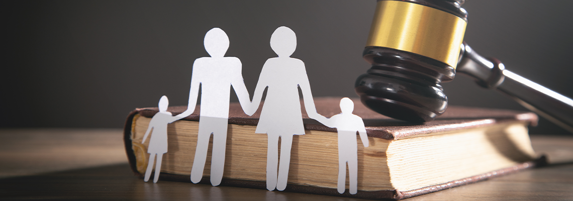 Paper Cutout of a Family, Judge's Gavel, and Book