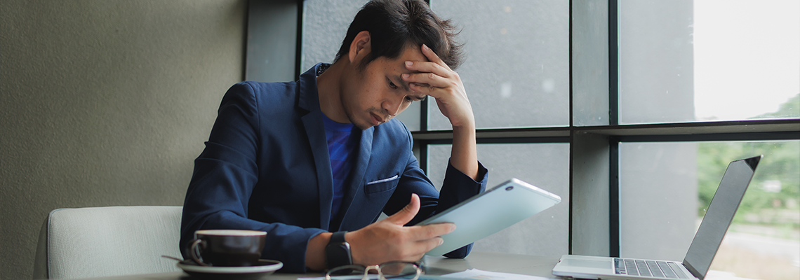 Male office worker overwhelmed by deadlines, staring at screen in frustration