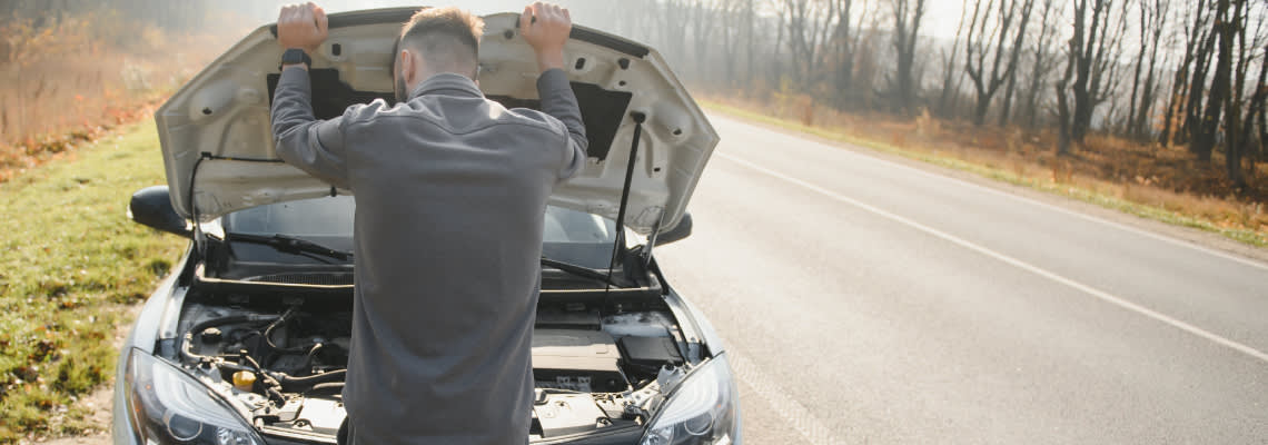 Upset man with broken car in road