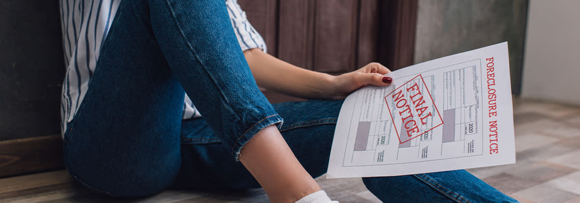 Cropped view of woman holding document with foreclosure notice