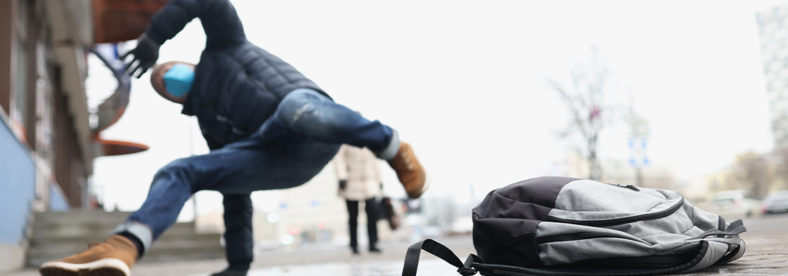 Male person get injury after falling on slippery ground in winter