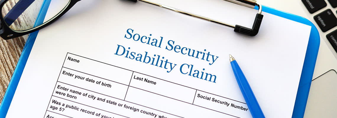 Social Security Disability Claim form in table with pen