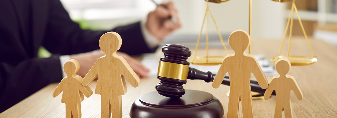 Gavel, sound block and little wooden figures of parents and children
