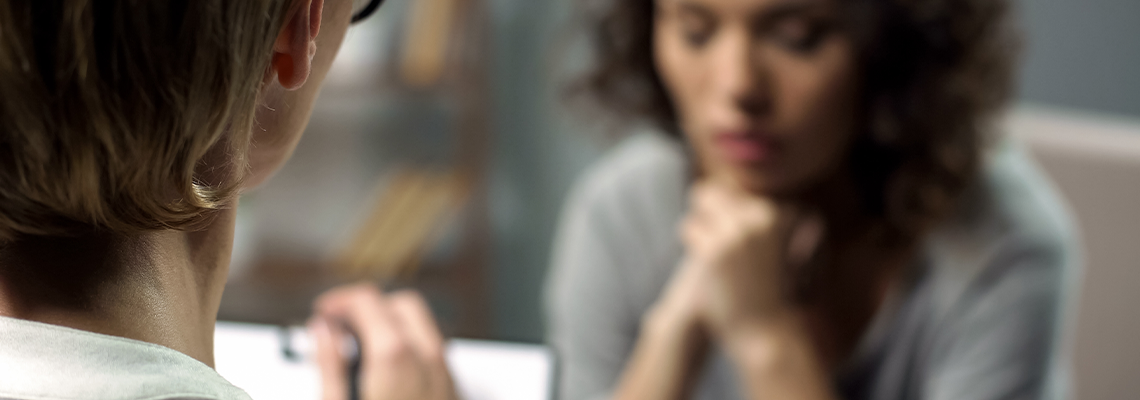 Young depressed woman talking to lady psychologist during session