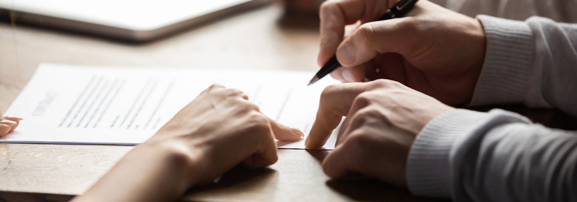 Solicitor pointing at contract showing client where to write signature