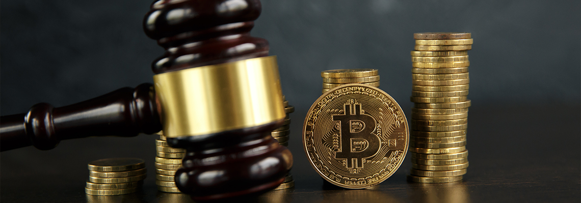 Auction gavel and bitcoin cryptocurrency money on a wooden desk