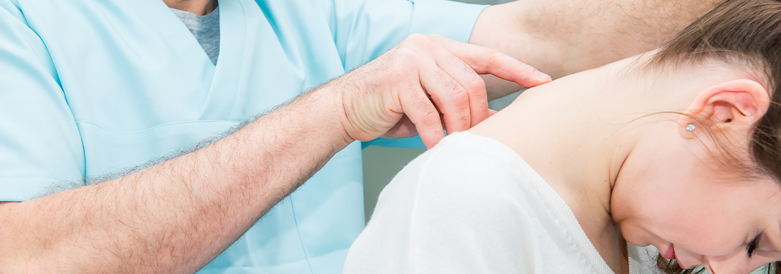 Close up Male neurologist doctor examines cervical vertebrae of female patient