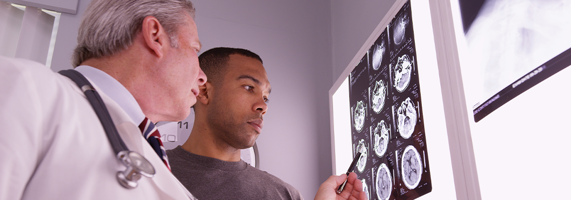 Mid aged medical doctor reviewing x ray of african patient
