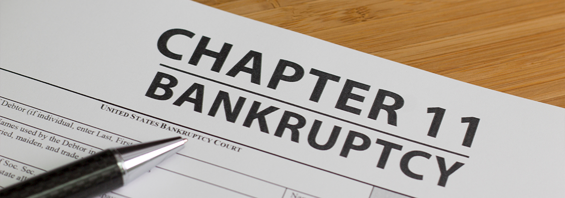 Bankruptcy Chapter 11 form with Pen on Table