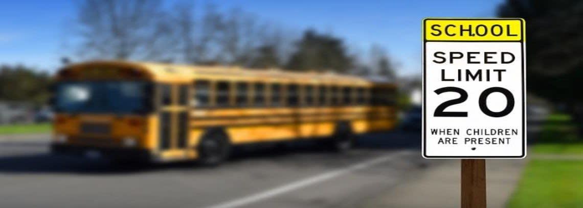 School Bus and an in focus Speed Limit sign