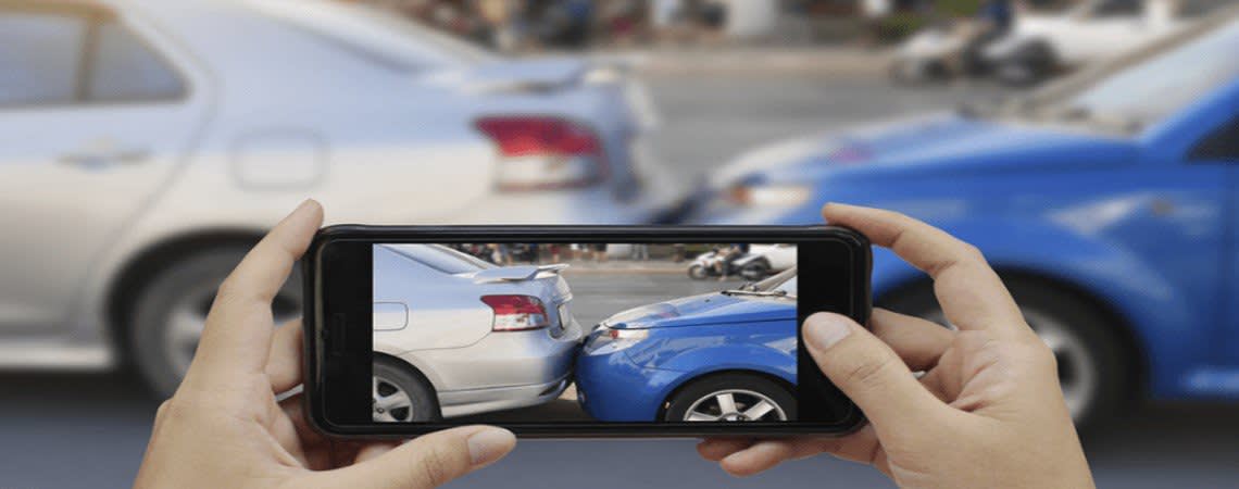 Person taking a photo of a fender bender with their smart phone