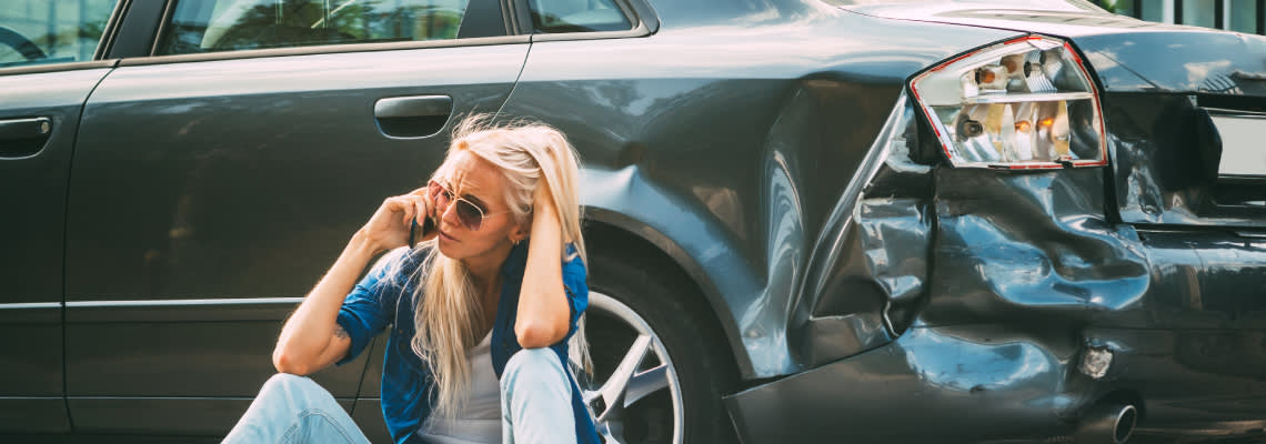 Worried female calling on phone after car accident