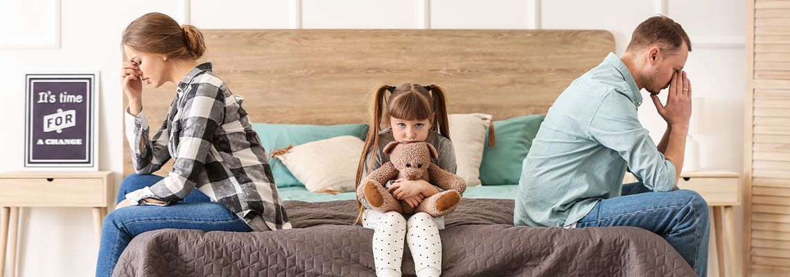 Sad family sitting on bed after quarrel