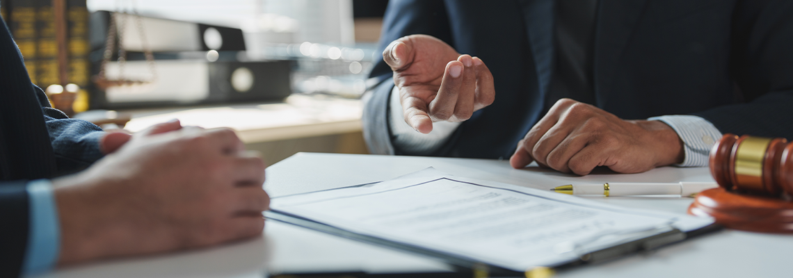 Two lawyers are sitting at a table, discussing the details of a contract