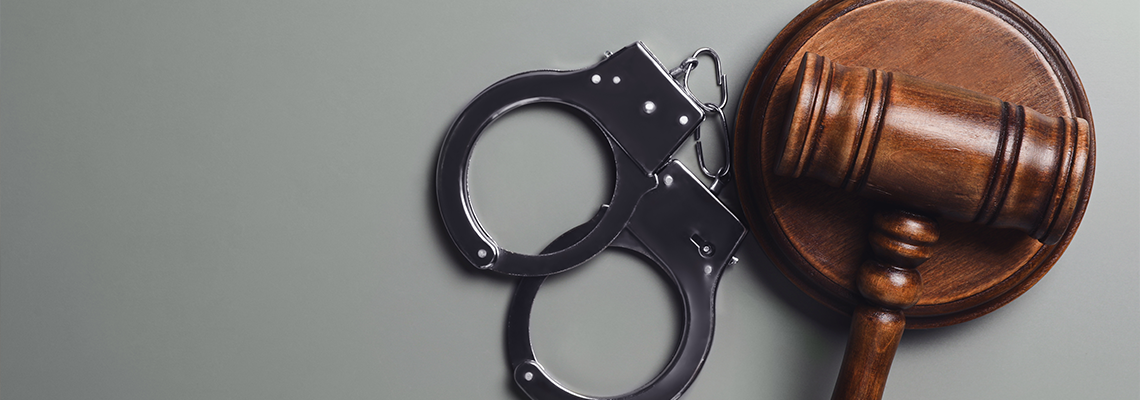 Judge's gavel and handcuffs on grey background, flat lay with space