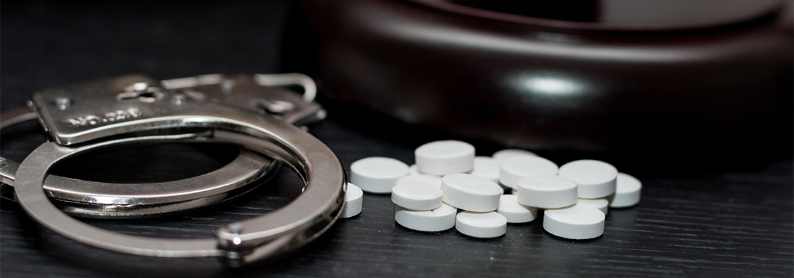 Judge's gavel with handcuffs, drugs on wooden table, drugs concept