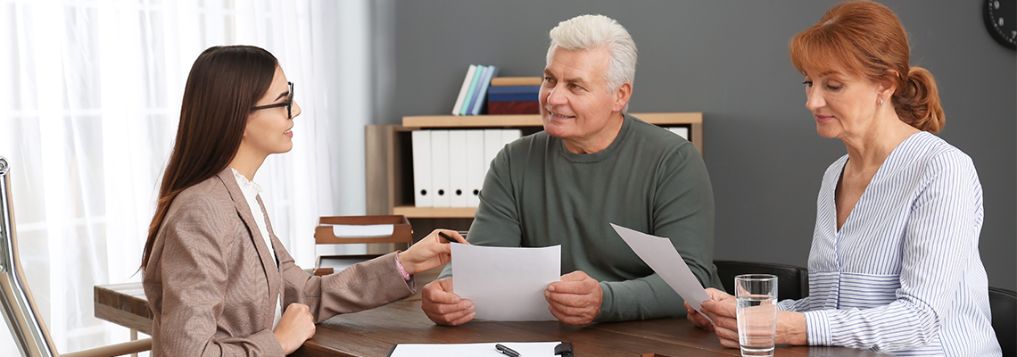 Young lawyer consulting senior couple in office
