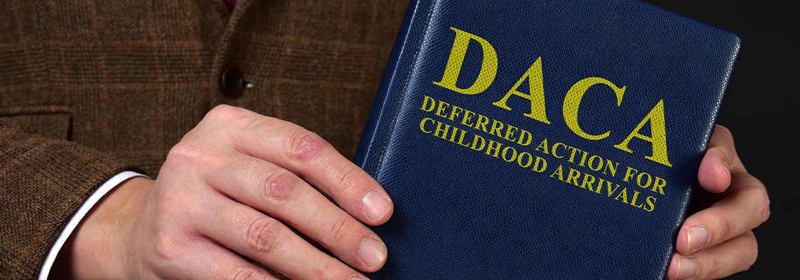 Man in suit shows the book Deferred Action for Childhood Arrivals DACA concept