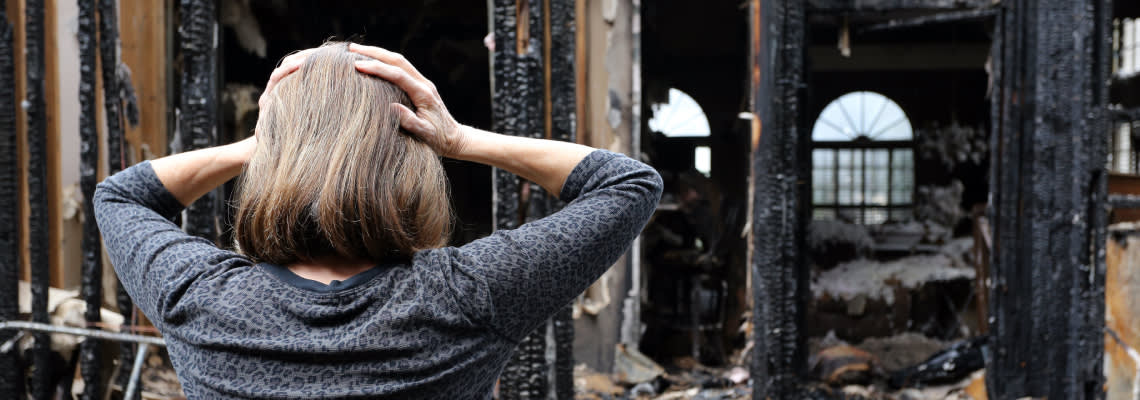 Sad women inspect damage after house fire