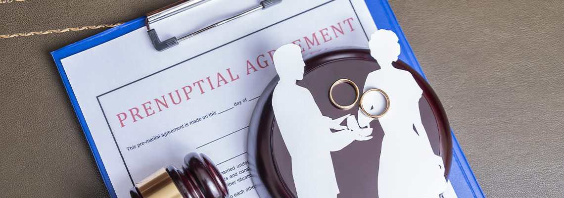 Prenuptial agreement form, gavel and couple papercut