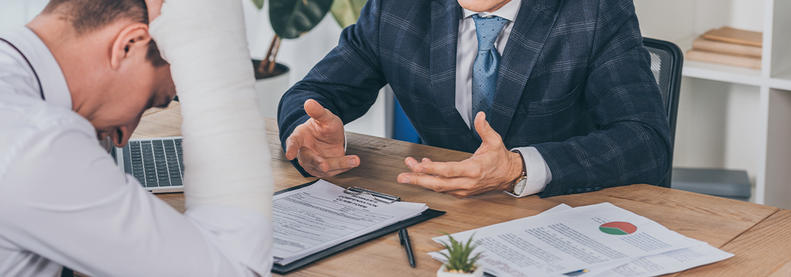 Injured Worker Reading Documents Opposite to Businessman