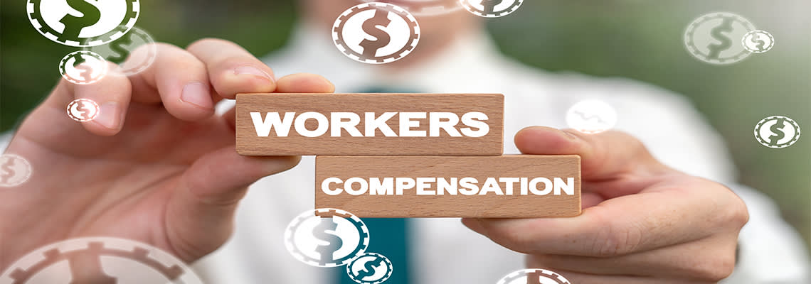 Person holding blocks with writing "workers compensation"