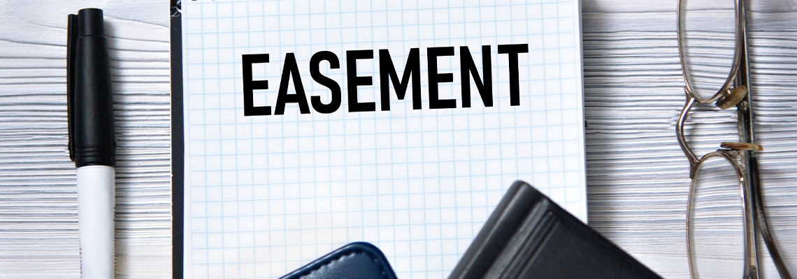 EASEMENT - word in white paper on the background of a diary, glasses and pen