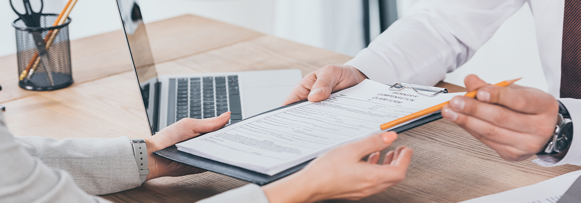 Businessman giving compensation claim form to woman at workplace
