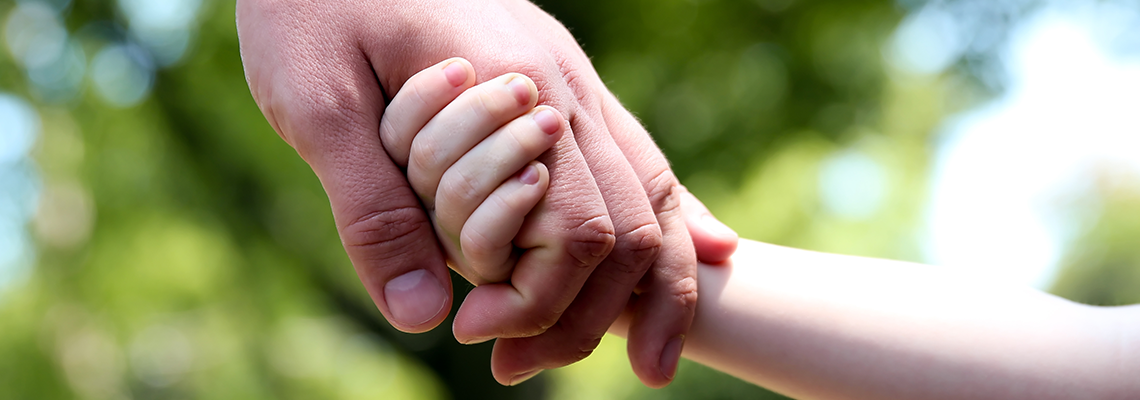 A child and adults hands holding