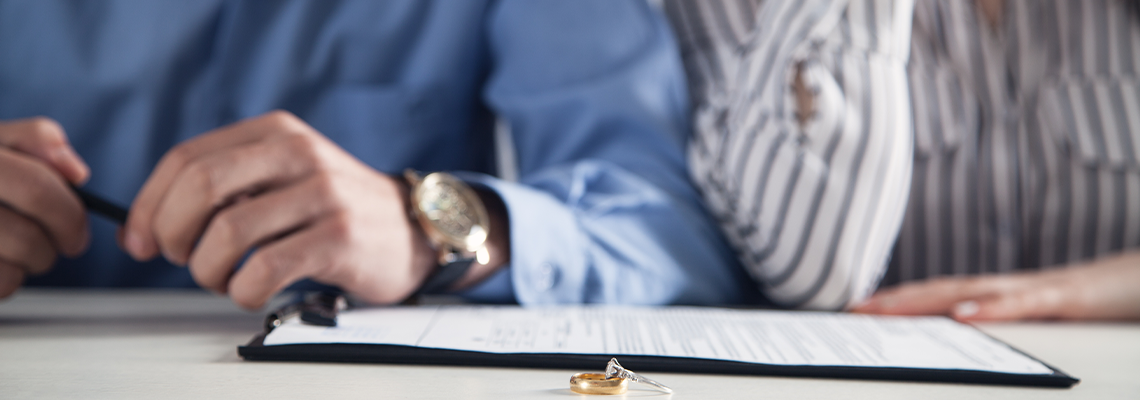 Couple with divorce contract and ring on desk