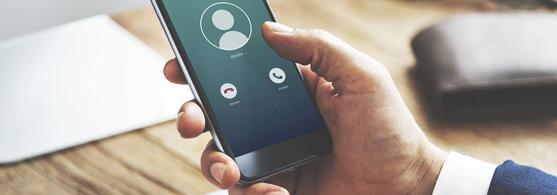 Person looking at an incoming call on their smartphone
