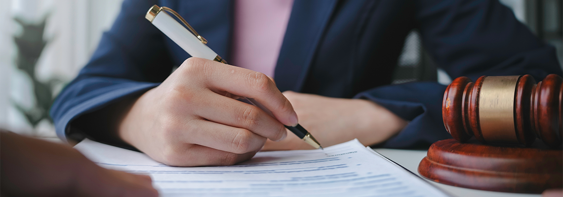 Lawyer is signing a last will and testament during a meeting with a client in their office