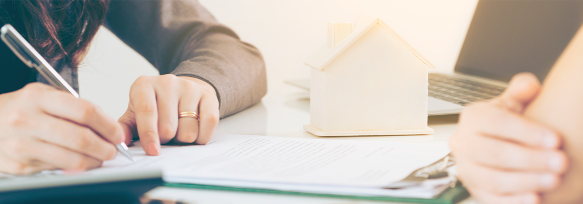 Person Signing Document on Desk