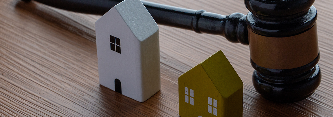 A gavel and two miniature wooden houses