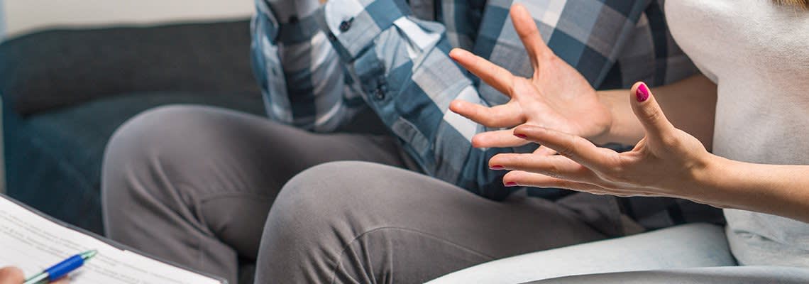 A frustrated woman sits next to a man