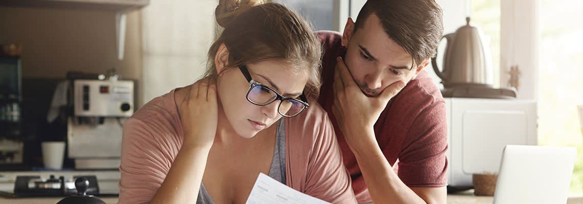 Couple looking at documents, worried about the future