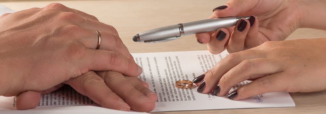Man and woman signing divorce paperwork