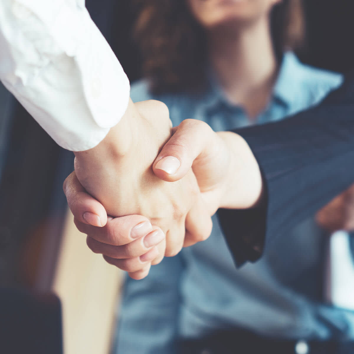 Young business people shaking hands in the office. Finishing successful meeting.