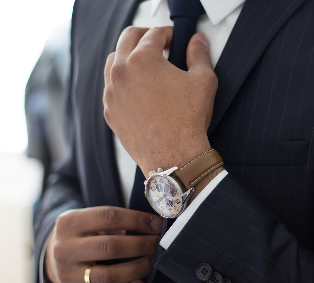 Man in suit adjusting his tie